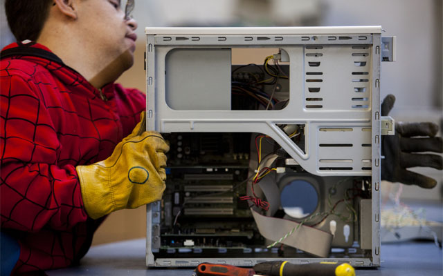 A volunteer disassembles computers at the University of San Diego E-Waste Center in San Diego, California, U.S. on Wednesday, Jan. 8, 2014